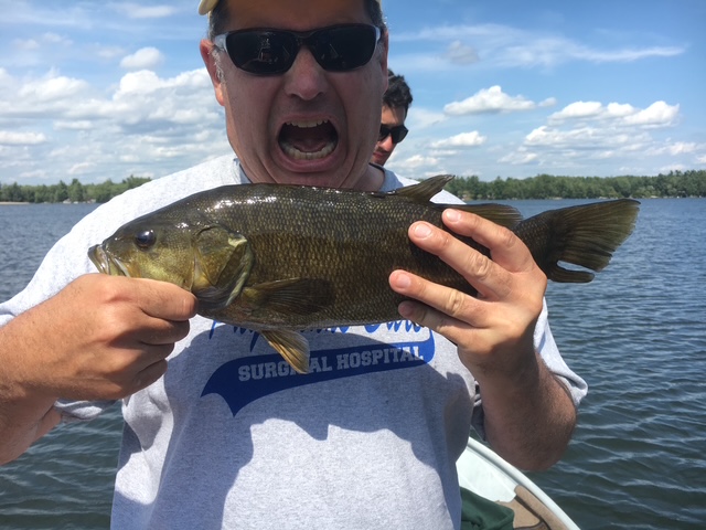 Young angler and guide with a smallmouth bass