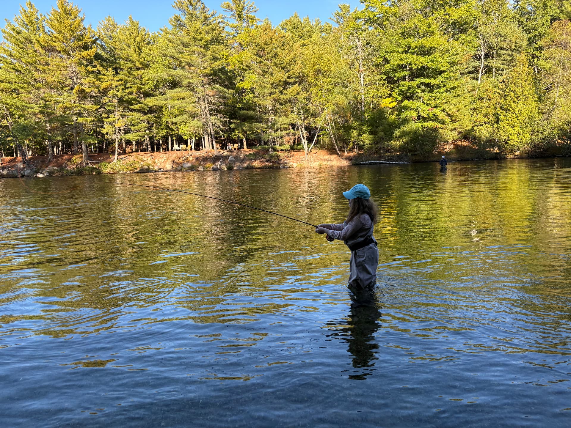 Fly angler wading a clear Maine river